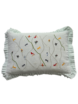 Decorative pillow with embroidered designs on a light green background