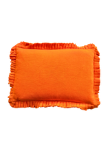 Orange pillow with ruffled edges on a white background