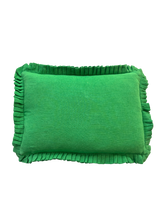 Green pillow with ruffled edges on a white background