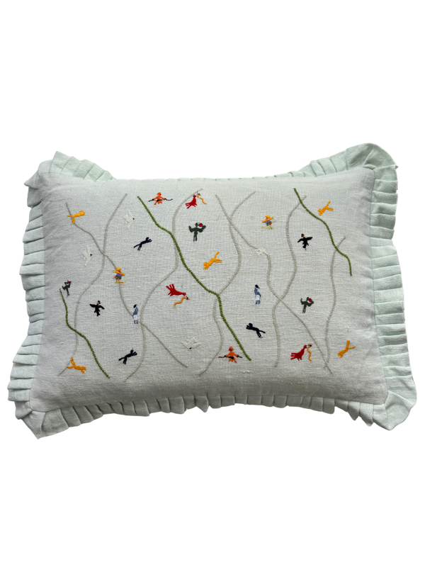 Decorative pillow with embroidered designs on a light green background