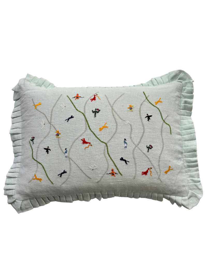 Decorative pillow with embroidered designs on a light green background