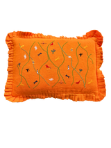 Orange pillow with embroidered designs on a white background