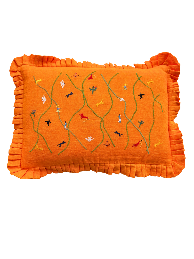 Orange pillow with embroidered designs on a white background