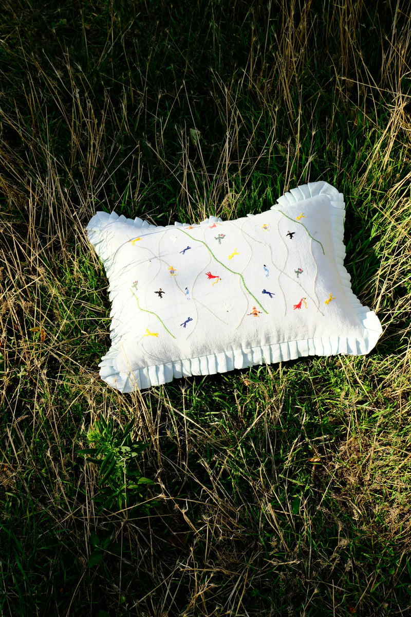 grey pillow with colorful patterns on grass