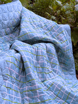 quilt with green and pink lines draped over a natural background