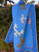 Asafo Blue quilt, printed design of a tree and various characters in natural background.