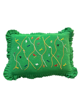 Green pillow with embroidered designs on a white background
