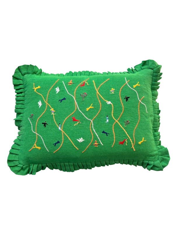 Green pillow with embroidered designs on a white background