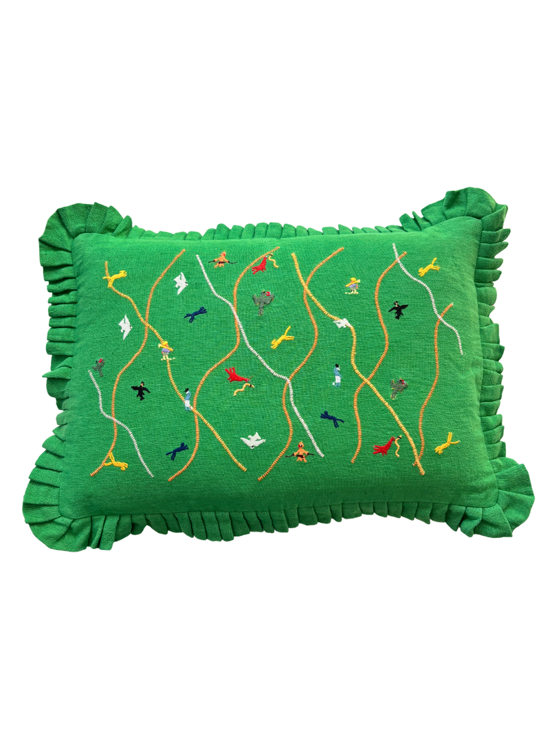 Green pillow with embroidered designs on a white background